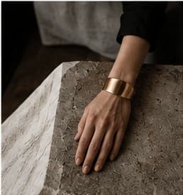 Hand resting on a sculptural stone surface